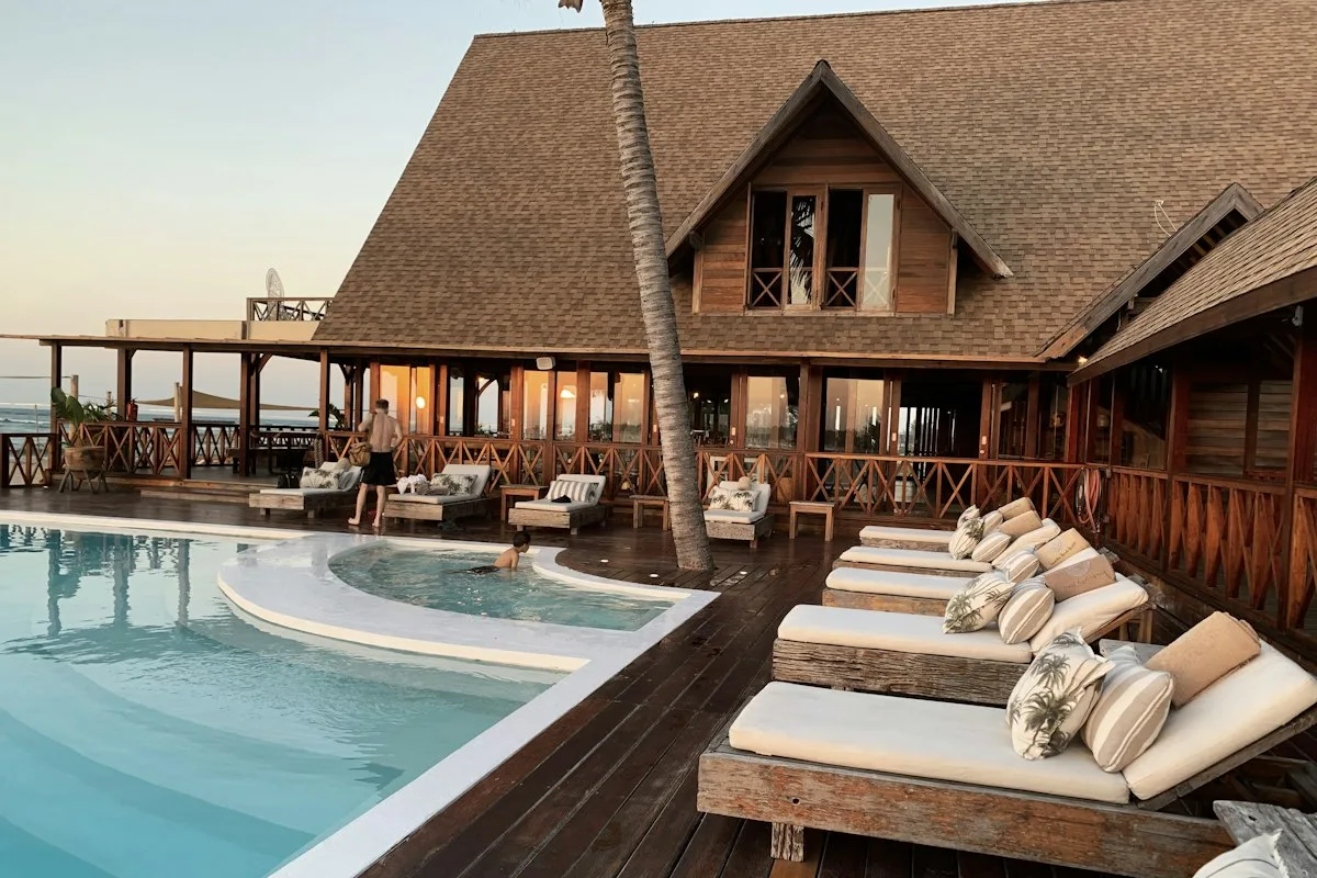 A pool and terrace beside a hotel building
