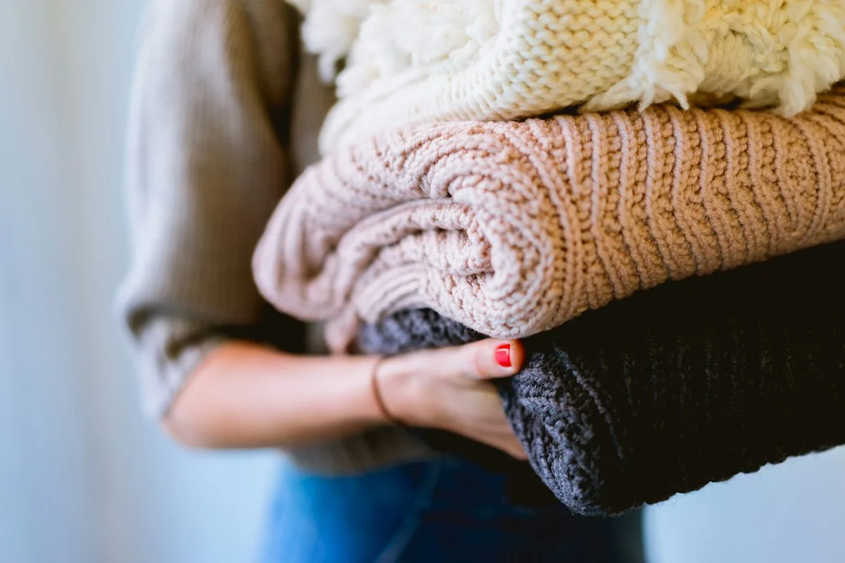 A person carrying folded clothing