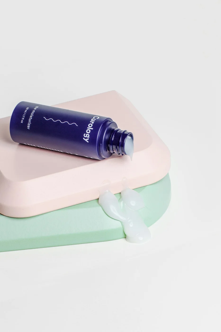Open purple cosmetic container on pastel surfaces