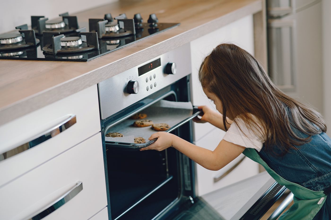 Woman placing a baking tray into an oven