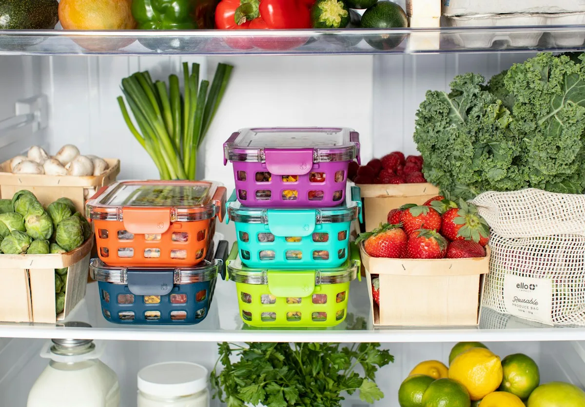 Open refrigerator with colourful produce baskets and vegetables